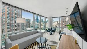 a living room with a couch and large windows at Sentral Michigan Avenue in Chicago
