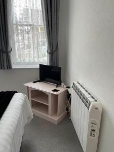 a bedroom with a bed and a desk with a computer at Franklyn Guesthouse in Saint Helier Jersey