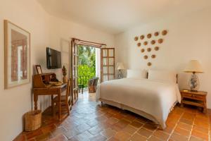 a bedroom with a bed and a table and a television at Hotel Santa Fe in Puerto Escondido
