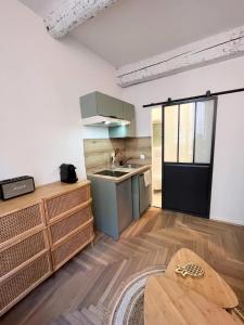 a kitchen with a sink and a table in a room at Cocon Hypercentre Aix-en-Provence in Aix-en-Provence