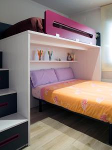 ein Schlafzimmer mit einem Etagenbett mit lila und orangefarbenen Laken in der Unterkunft Cal Negri in Vilafranca del Penedès