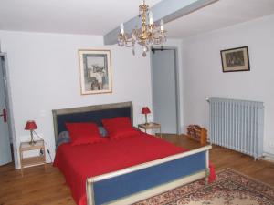 a bedroom with a bed with red pillows at Chambres d'hôtes Ferme de Gayri in Vielle-Aure