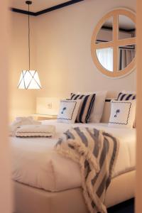 a bedroom with two beds and a mirror on the wall at Grande Real Santa Eulalia Resort & Hotel Spa in Albufeira