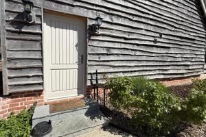 a white door on the side of a house at The Hayloft in Ringwood