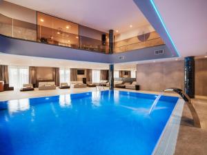 a large swimming pool in a hotel lobby at Diaco Boutique Hotel in Đakovo