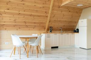 a kitchen with a table and chairs and wooden walls at Hyde Retreat in Holda