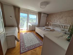 a living room with a couch and a large window at Apartments & Rooms Aleksandra in Bled