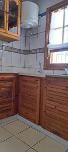a kitchen with wooden cabinets and a sink and a window at Dar Mnasri in Houmt Souk +35 photos