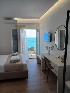 a bedroom with a bed and a desk and a mirror at NaDim rooms in Himare