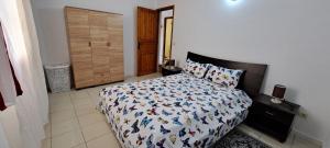 a bedroom with a bed with a comforter on it at Dar Mnasri in Houmt Souk