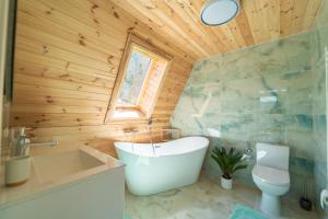 a bathroom with a tub and a sink and a toilet at Hyde Retreat in Holda
