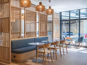 a restaurant with wooden walls and tables and chairs at Novotel Marseille Centre Gare in Marseille