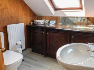 a bathroom with a sink and a toilet and a window at Pearls Farm One in Macclesfield