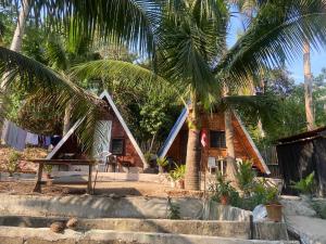 a house with palm trees in front of it at Sea Breeze Camp in Siquijor +7 photos