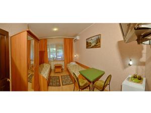 a small room with a green table and chairs at Hotel Na Kuznechnoy in Saratov