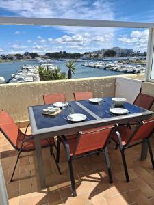 a table on a balcony with a view of a harbor at Résidence soleilla in Le Barcarès