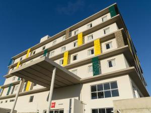 a white building with yellow and green accents on it at ibis Arcoverde in Arcoverde