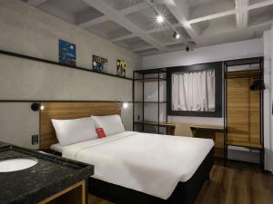 a bedroom with a white bed and a sink at ibis Arcoverde in Arcoverde +168 photos