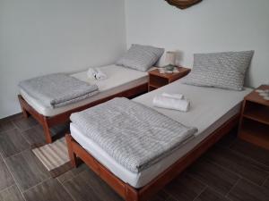 a room with two beds and two night stands at Dudov Hlad in Batina
