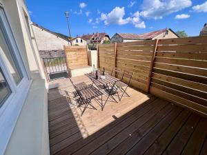 a deck with two chairs and a fence at La Terrasse de Mâlain in Mâlain