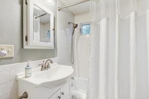 a white bathroom with a sink and a shower at Gingerbread Cottage in Sugar Hill +40 photos