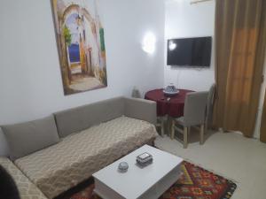 a living room with a couch and a table at Taguermess Tag 1 in Midoun