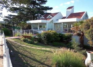 a large white house with a fence in front of it at CRISTAL BuenaVista in Villa Carlos Paz +15 photos