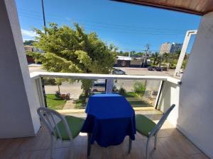 a blue table and chairs on a balcony with a view at Pousada recanto das ondas in Macaé