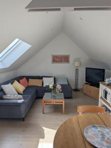 a living room with a blue couch and a tv at Chez Sophie in Plescop