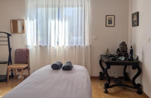 a bedroom with a bed and a table and a window at Chez Sophie in Plescop