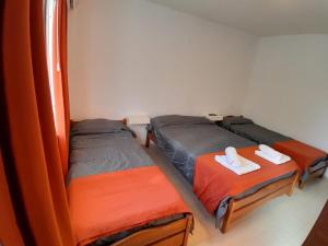 two twin beds in a room with orange sheets at CRISTAL BuenaVista in Villa Carlos Paz
