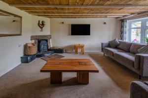 a living room with a couch and a fireplace at Courtyard Farm Cottages in Boscastle