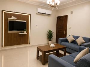 a living room with a blue couch and a table at تراس للشقق المخدومة in Dammam
