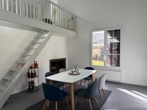a white dining room with a table and chairs at La Maisonnette de Fontaine - Au calme avec jardin in Fontaine-sous-Jouy