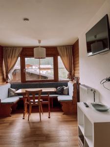 ein Esszimmer mit einem Tisch und einem Fenster in der Unterkunft Das Luis in Altenmarkt im Pongau