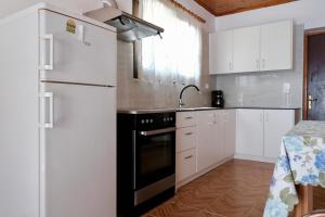 eine Küche mit weißen Schränken und einem schwarzen Kühlschrank in der Unterkunft Irini Studios in Alykes + 50 Fotos