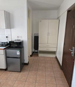 a small kitchen with a counter and a refrigerator at Emeli Suites in Nairobi
