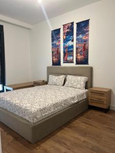 a bedroom with a bed with three paintings on the wall at becici residance with pool & sauna in Budva +7 photos