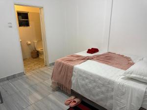 a bedroom with a bed with a red towel on it at Shukuru Guest House in Harare