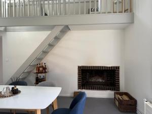 a living room with a white table and a fireplace at La Maisonnette de Fontaine - Au calme avec jardin in Fontaine-sous-Jouy