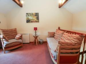 a bedroom with two beds and a chair in a room at Pearls Farm Two in Macclesfield