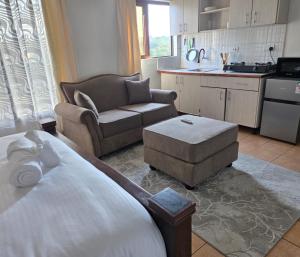 a bedroom with a bed and a couch and a chair at Emeli Suites in Nairobi