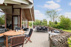 a patio with a wooden table and chairs at LF16031-Farso-Spydspidsevej-31 in Ertebølle
