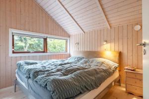 a bedroom with a bed in a room with a window at LF16031-Farso-Spydspidsevej-31 in Ertebølle
