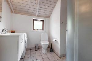 a bathroom with a toilet and a sink and a window at LF16031-Farso-Spydspidsevej-31 in Ertebølle +13 photos