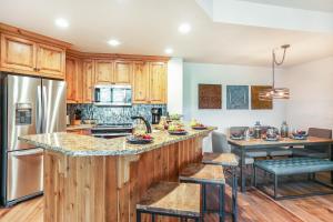 a kitchen with wooden cabinets and a large island with bar stools at 104 Highlands Westview in Avon