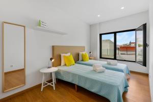 a white bedroom with two beds and a window at JB RiaMar ll by Meditrust in Alvor +13 photos