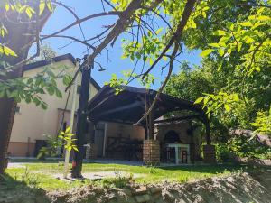 a building with a black awning in a yard at Dudov Hlad in Batina
