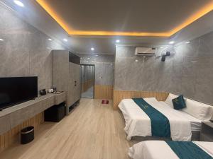 a hotel room with two beds and a flat screen tv at Victory Hotel in Xóm Hương Phùng