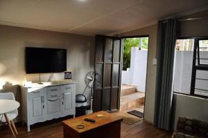 a living room with a tv on the wall at 22 Symmonds Studio in Melmoth
